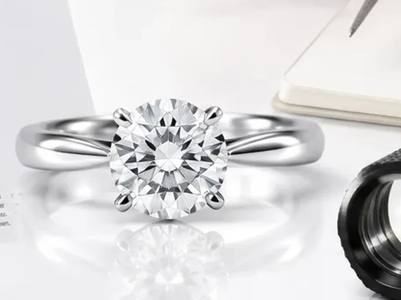 Brilliant-cut diamond engagement ring examined with a jeweller's loupe